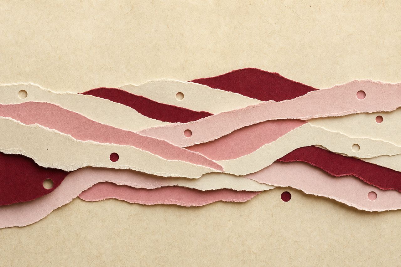 Een horizontale band van overlappende gescheurde papierstroken over perkament, elke strook in een andere tint, met geponste cirkels op regelmatige afstand (met AI gemaakte afbeelding)